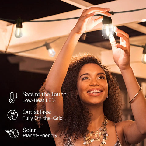 Woman enjoying the Solar Powered Outdoor String Lights 48 Ft Commercial Grade Waterproof Patio Lights With 15 Shatterproof LED Edison Bulbs Soft White