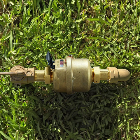Three Quarter Inch Non Pulsed Rotary Piston Water Meter with heavy-duty brass construction on grass