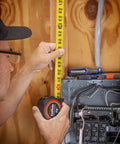 Person using 1-3/16 Inch By 25 Foot Command Control Series Yellow Clad Tape Measure With Anti-Pinch Retractable Tape L1025C-02