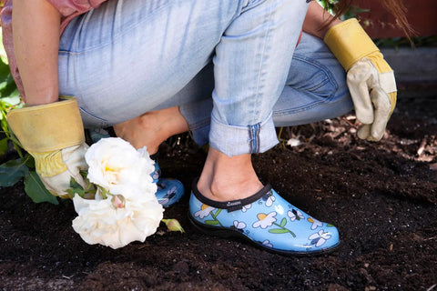 Women's Waterproof Rain Kicks Slip-On Garden Clog With Heavy-Duty Arch Support And All-Day Cushy Comfort For Busting Through Puddles And Tackling Yard Chores In Light Blue Bee Print, worn while gardening.