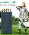Must Have Outdoor Storage Cabinet And Potting Bench With Metal Top Shelves For Patio Garden Easy Setup Weatherproof Wooden Planting Workstation In Anthracite Grey next to a person gardening.
