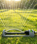Oscillating Yard Sprinkler Workhorse with 18 brass nozzles on a lawn, gray body spraying water, adjustable range, clog resistant, 3600 sq ft coverage