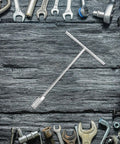 Ergonomic Steering Wheel T Handle Socket Wrench Made From Tough American Steel For Motorcycle Repair, centered among tools.