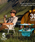 Man relaxing beside yellow tent with blue Lightweight Portable Camping Picnic Table With 4 Cup Holders And Carry Bag, Folding Beach Table