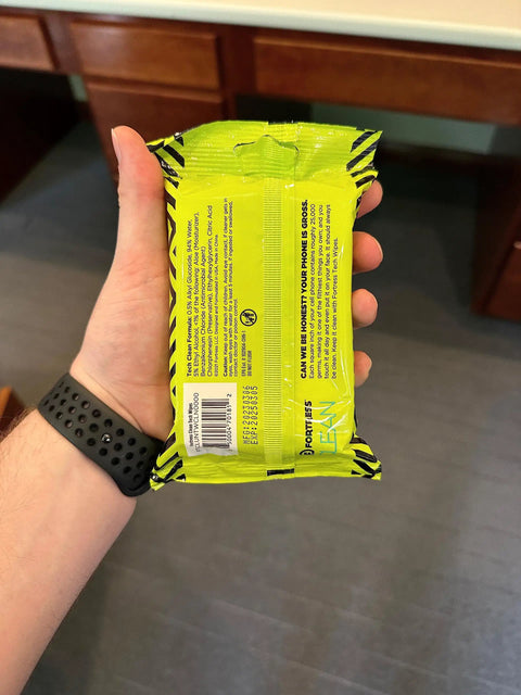 Person holding a pack of To Go Tech Wipes 25 Count Skin Safe Electronics Cleaning Wipes For Screens Phones Tablets Laptops Keyboards Monitors