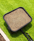 Tow Behind Lawn Spreader For Seed Fertilizer Ice Melt, 9.8 Foot Spreading Width, 85 Lb Hopper, on grassy lawn with seeds