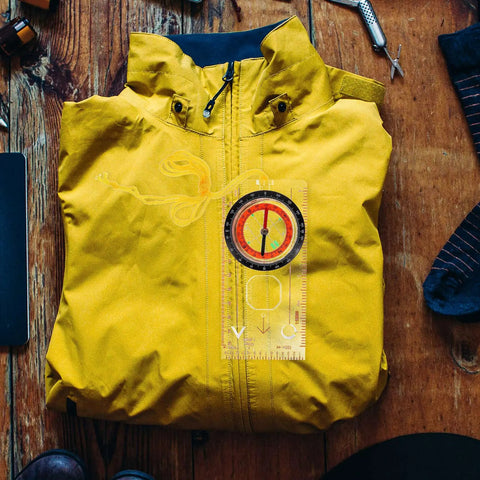 Compact Measuring Compass And Ruler Navigation Tool For Hiking And Camping on yellow jacket, sturdy survival gear.
