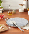 Kitchen counter with 13 Inch Soapstone Pizza Stone With Stainless Steel Tray And Cutter, Silver, showcasing durability and design.