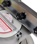 Close-up of adjustable angle gauge on Shop Grade Cast Iron Knife And Cutter Grinder with robust metal knobs and safety label.
