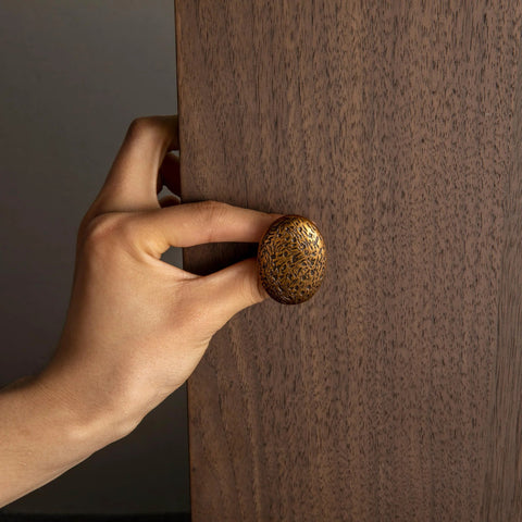 Close-up of hand installing antique brass zinc alloy drawer knob, Six Pack Zinc Alloy Drawer Knobs In Big Oval Antique Brass Finish