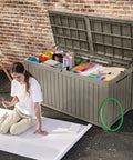 Beefy 220 Gallon Outdoor Deck Storage Box with Removable Divider, light brown, open with art supplies visible, woman sitting nearby