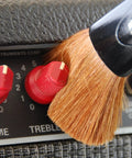 Nomad String Body And Hardware Cleaning Tool For Guitars And Bass Extends String Life, Preserves Tone, And Cleans Strings, Body, And Hardware In Seconds With A Premium Microfiber Pad No Cleaning Solution Needed. close-up on guitar amp knobs