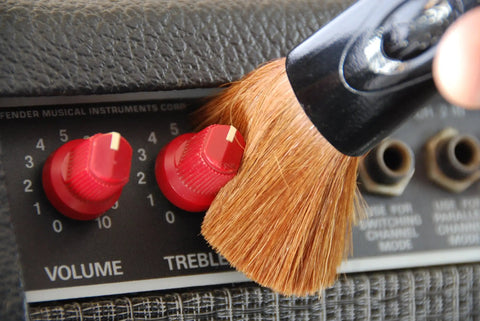 Nomad String Body And Hardware Cleaning Tool For Guitars And Bass Extends String Life, Preserves Tone, And Cleans Strings, Body, And Hardware In Seconds With A Premium Microfiber Pad No Cleaning Solution Needed. close-up on guitar amp knobs