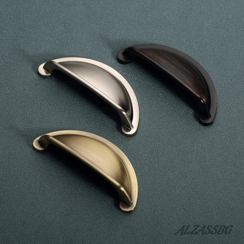 Premium Upgraded Top Shelf 3 Inch Brushed Antique Brass Cabinet Cup Pulls shown in three finishes on textured background.