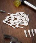 Top Shelf White Shutter Repair Pins Twenty Pack One By Point Two Five Inch Louver Pins Heavy Duty Plantation Shutters Replacement Hardware on a wooden surface.
