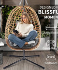 Woman sitting in Egg Chair With Stand Outdoor Patio Wicker Swing Chair For Balcony Garden Cozy Lounge 350 Lbs Capacity Cushioned Ergonomic Design With Thick Cushion For All Day Comfort Weatherproof Frame Easy To Assemble indoors.