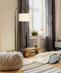 Nora Arc LED Tall Floor Lamp With Heavy Base For Living Room And Office in cozy room setting, sleek black with linen shade