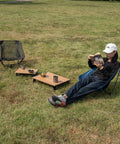 Person relaxing with Ultralight Compact Mini Beach Picnic Folding Aluminum Table With Carry Bag Nature Finish Flat Surface Durable Hinges