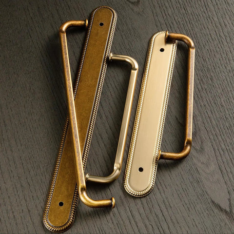 Game Changing Antique Brass Cabinet Pulls and Drawer Handles, 5 Inch Hole Center Zinc Alloy Kitchen Hardware With Vintage Backplate and Spacer, Rock Solid Corrosion Resistant Shine Makes Assembly As Easy As Pie in This 2 Pack to Spice Up Your Kitchen - close-up of two antique brass handles on a wooden surface.