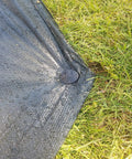 Black heavy duty outdoor stake securing black tarp on grass, part of 30 Pack 4.3 Inch Plastic Stakes Anchors Beefy Rustproof Thick Resin For Holding Down Landscape Fabric Lawn Edging Tents Game Nets And Rain Tarps Black Heavy Duty Outdoor Stakes Set