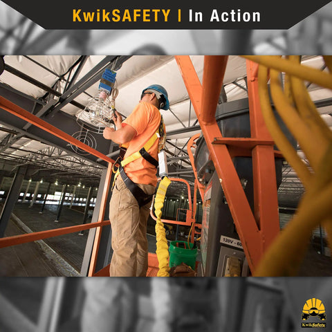 Worker using Thunder 3D Ring Safety Harness 2 Pack Full Body Fall Protection OSHA ANSI Industrial Safety Gear For Construction Pros Carpenters Scaffolders and Contractors, inspecting ceiling wiring on scaffold with harness attached.