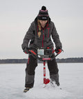 Woman using Rock Solid Pistol Bit Adapter For Auger Powerheads on ice with Eskimo auger, wearing winter gear.