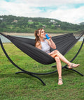 Heavy Duty Hammock Stand With Portable Foldable Patio Hammock For Backyard Or Deck, Sturdy Steel Frame With Non Slip Feet, Supports Up To 475 Lbs, Fits 2 To 3 People, Dark Gray Outdoor Lounging featuring a woman relaxing outdoors.