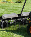 Tow Behind Dethatcher Powerful 40 Inch With 20 Spring Steel Tines attached to a tractor, showing lift handle and weight blocks on grass.