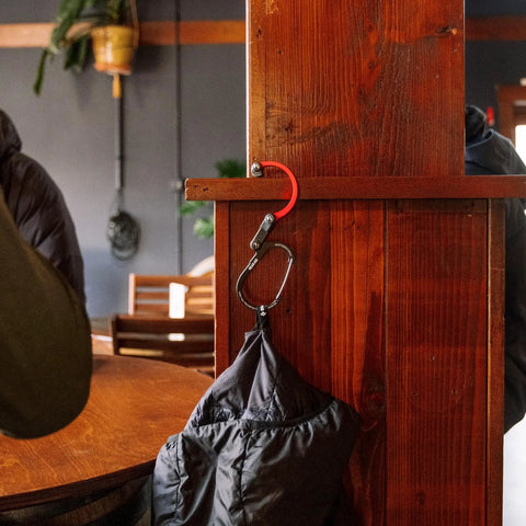 HeroClip Medium Carabiner Gear Clip And Hook For Camping Backpack And Garage Organization hangs bag on wooden beam