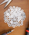 Aluminum Back Up Rivet Washers For 1/4 Inch POP Rivets 310 Pieces on wooden surface with tools around