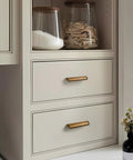 Five Pack 5 Inch Antique Brass Cabinet Cup Pulls For Kitchen And Bath installed on white drawers, 128mm length.