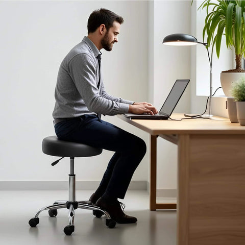 Man sitting on a Rolling Exam Stool with Wheels, 18.5 Inch to 25 Inch Adjustable Height for Dentists, Spas, & Healthcare Environments, 5 Casters, Easy Assembly, Black.