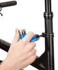 Using Park Tool ATD-1.2 Adjustable Torque Driver Tool, Blue, on bicycle frame for precise torque adjustment.