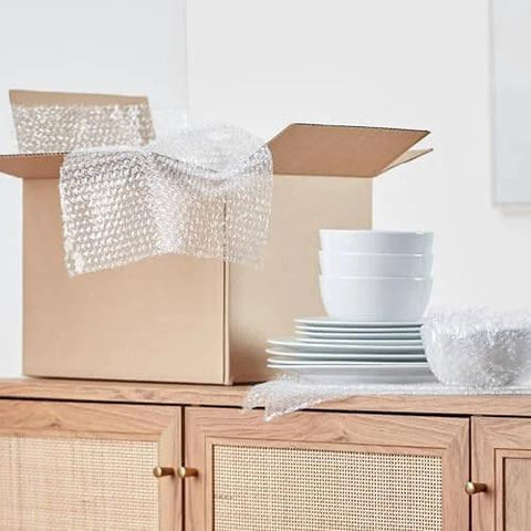 Bubble Cushioning Wrap For Fragile Items Perforated 12 Inch Roll 175 Ft Clear With Small Three Sixteenth Inch Bubbles next to dishes