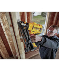 Man using DEWALT 20V MAX XR Framing Nailer to drive nails into a wooden frame on a construction site