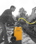 Man using FLO-FAST Pro Pump, 8GPM, Telescoping Draw Tube to transfer fluid to vehicle in outdoor construction setting