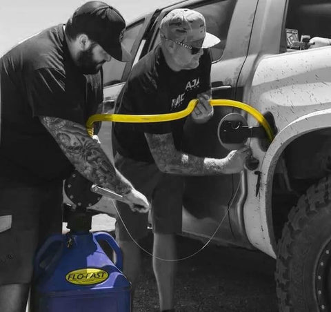 Two men using FLO-FAST Pro Pump, 8GPM, Telescoping Draw Tube, fits Containers and Barrels, Portable, Durable, Made in USA.