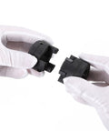 Close-up of black plastic L-jaw coupling halves from a 3-piece set with Buna-N rubber spider, held by gloved hands