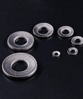 Assorted 304 stainless steel Belleville spring washers in M3 to M12 sizes on black background