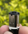 Close-up of DC 3V 5V 6V Mini N20 Planetary Gearbox Gear Reducer Motor Cross Shaft in hand against greenery backdrop