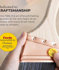 Hand holding Purdy paintbrush with wooden handle and copper ferrule, showcasing craftsmanship dedication badge.