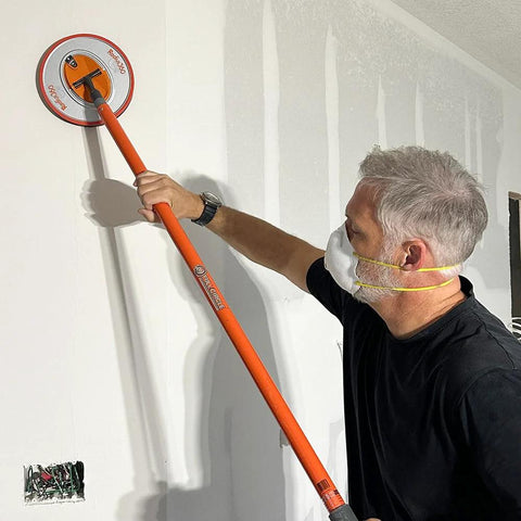 Man using Radius360 Round Sanding Tool With Interchangeable Center Hub 9 Inch on a wall
