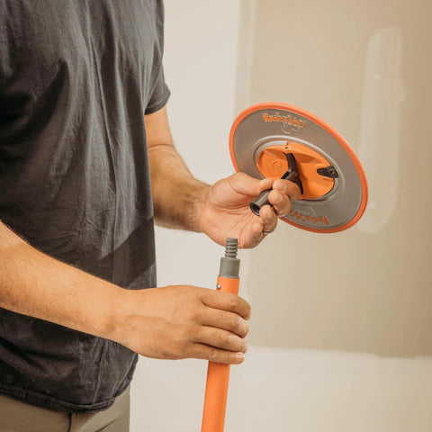 Person assembling Radius360 Round Sanding Tool With Interchangeable Center Hub 9 Inch, showing round pad and handle attachment.