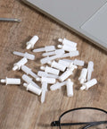 60 Pcs Shutter Repair Pins Shutter Louver Spring Loaded Replacement Pins next to laptop and glasses on wood surface
