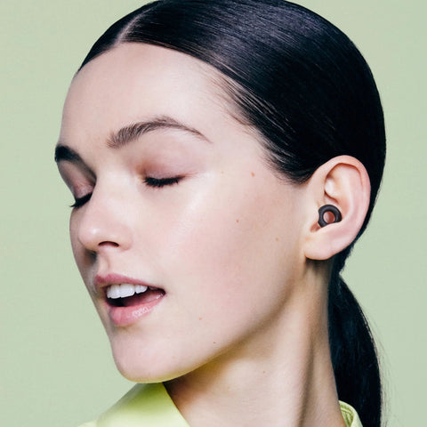 Woman wearing Ultra Comfortable Reusable Ear Plugs With 24 Decibel SNR Noise Reduction For Sleep Deep Focus Travel And Noise Sensitivity