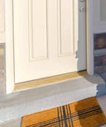 Solid Red Oak Interior Threshold installed at doorway, showing durable wood transition with doormat, enhancing entry look. Size: 36 x 3 x 1 inches.
