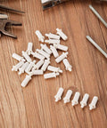 40 Pieces Shutter Repair Pins, Plantation Shutter Fasteners Spring Loaded Replacement Repair Pins, white pins on wood surface.