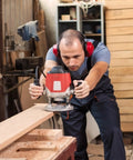 Woodworker uses router in workshop; ideal for Five Sixteenth Inch Internal Threaded Clamping Knobs for precise routing setups